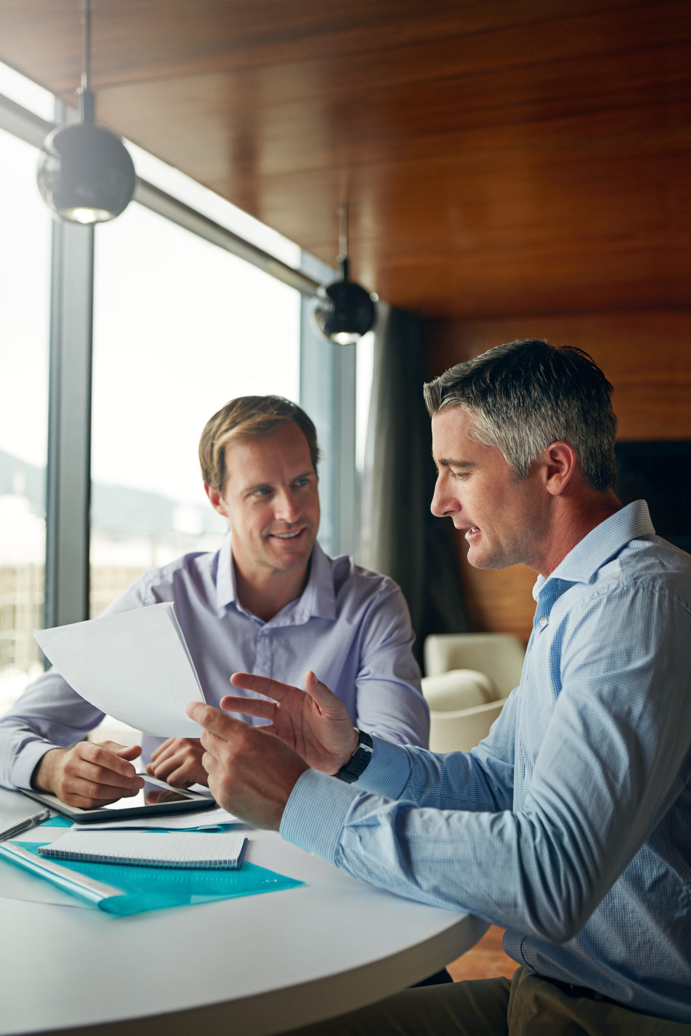 Shot of two businessmen discussing paperwork while sitting in an office