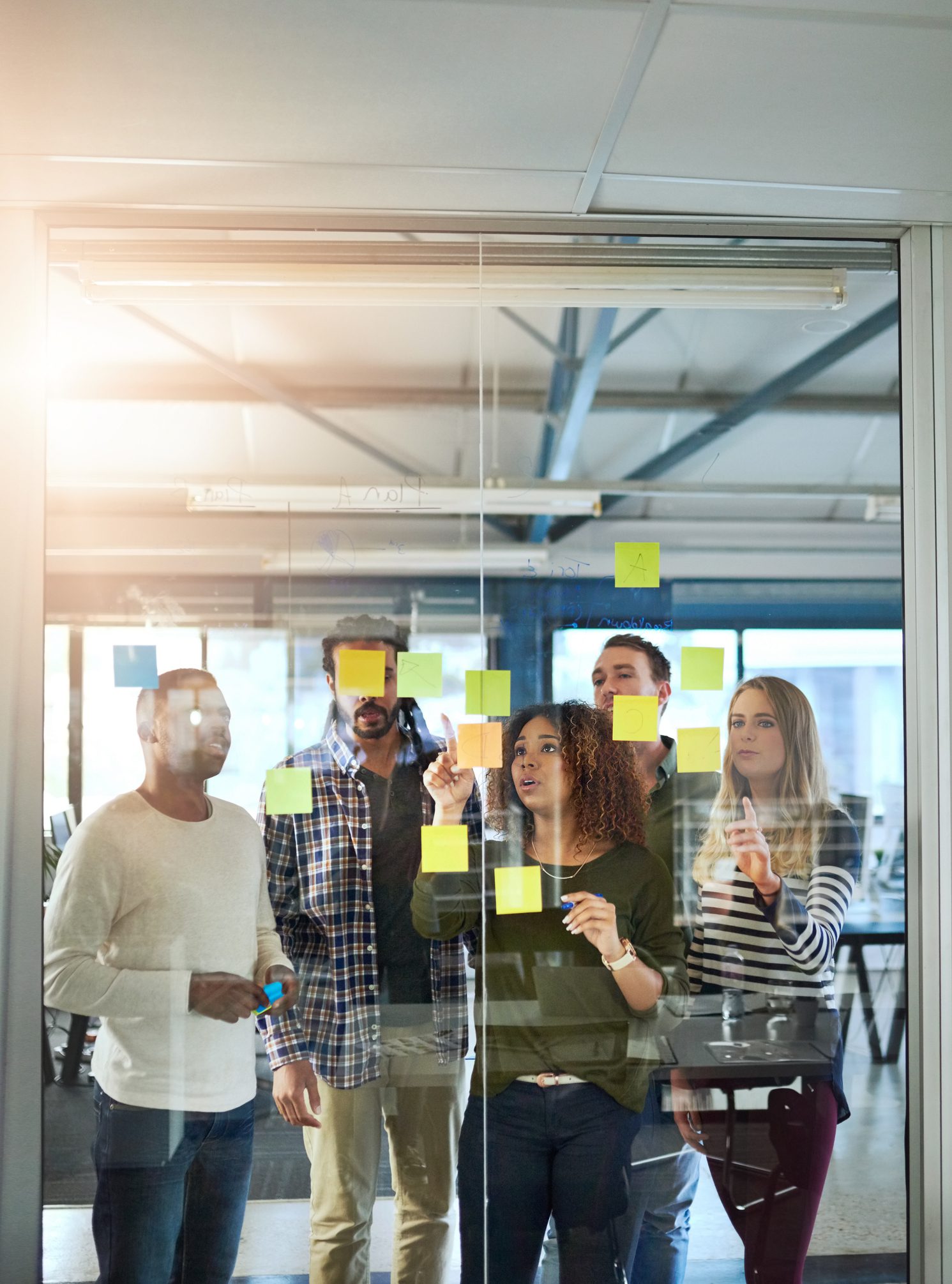 Shot of colleagues having a brainstorming session with sticky notes at work